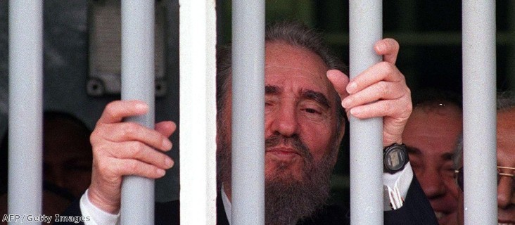 Fidel Castro peers out of the bars of Nelson Mandela's former cell on Robben Island during a recent visit.