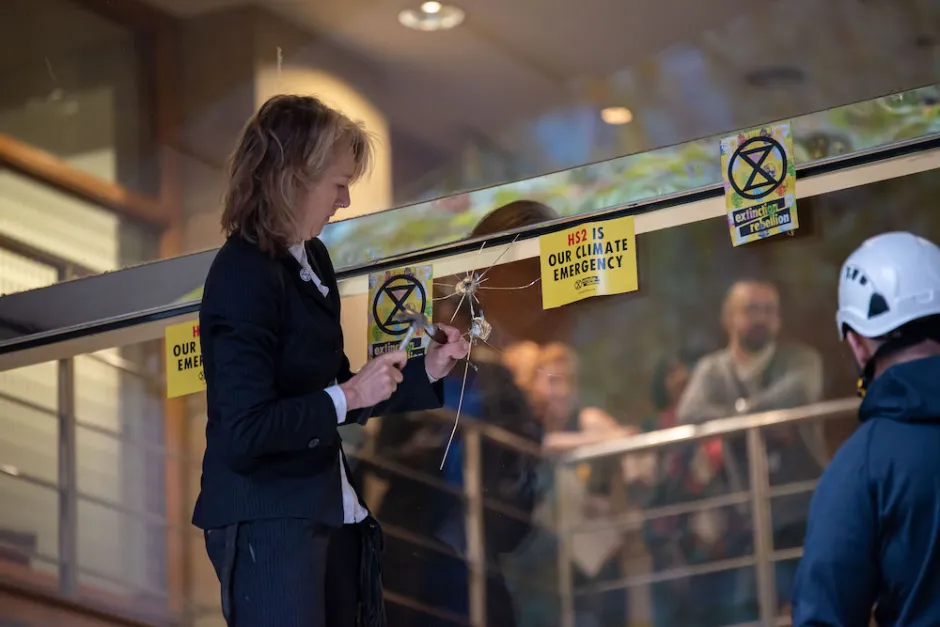 Gail Bradbrook damaging a very expensive window. Image: Extinction Rebellion UK