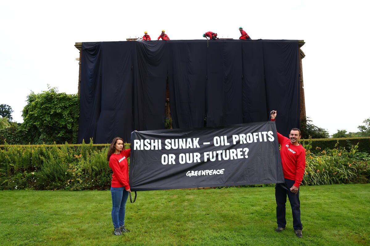 Greenpeace cover Rishi Sunak's home in black oily fabric in protests at Sunak's intended huge expansion of North Sea fossil fuel exploration.