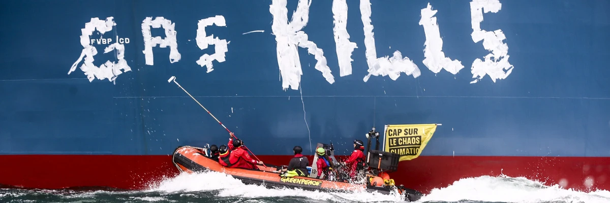 Greenpeace activists paint "Gas kills" on the hull of the Cape Ann.